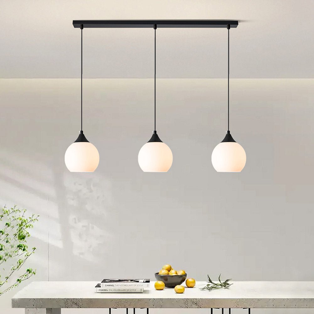 Make a stylish statement in your kitchen with the 3-Light Linear Pendant with Opal Globe Glass Shade. Featuring a sleek black metal frame with three elegant milky glass globes, this modern-looking linear pendant light will provide beautiful illumination above kitchen islands or counters. Create a shining, inviting atmosphere that will leave your guests in awe!