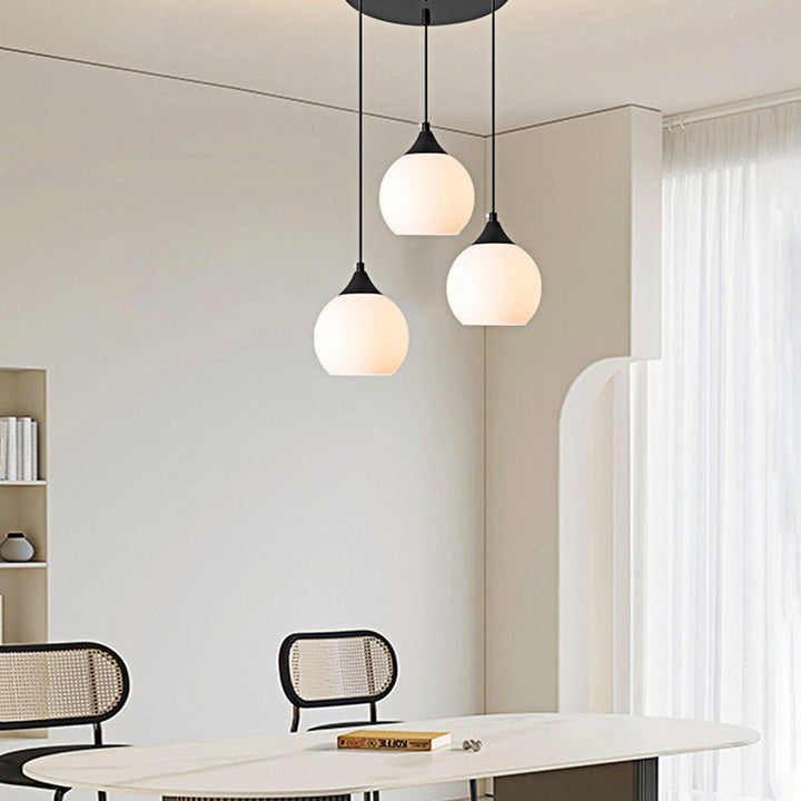 Adorn your kitchen island or dining room with this modern 3-light pendant. The round canopy and milky glass shades evoke an air of sophistication, while the black metal finish creates a sleek, contemporary look. Illuminate your space with this stylish and functional light fixture!